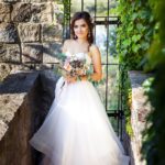 Beautiful young bride with a bouquet of wedding flowers. Holiday dress